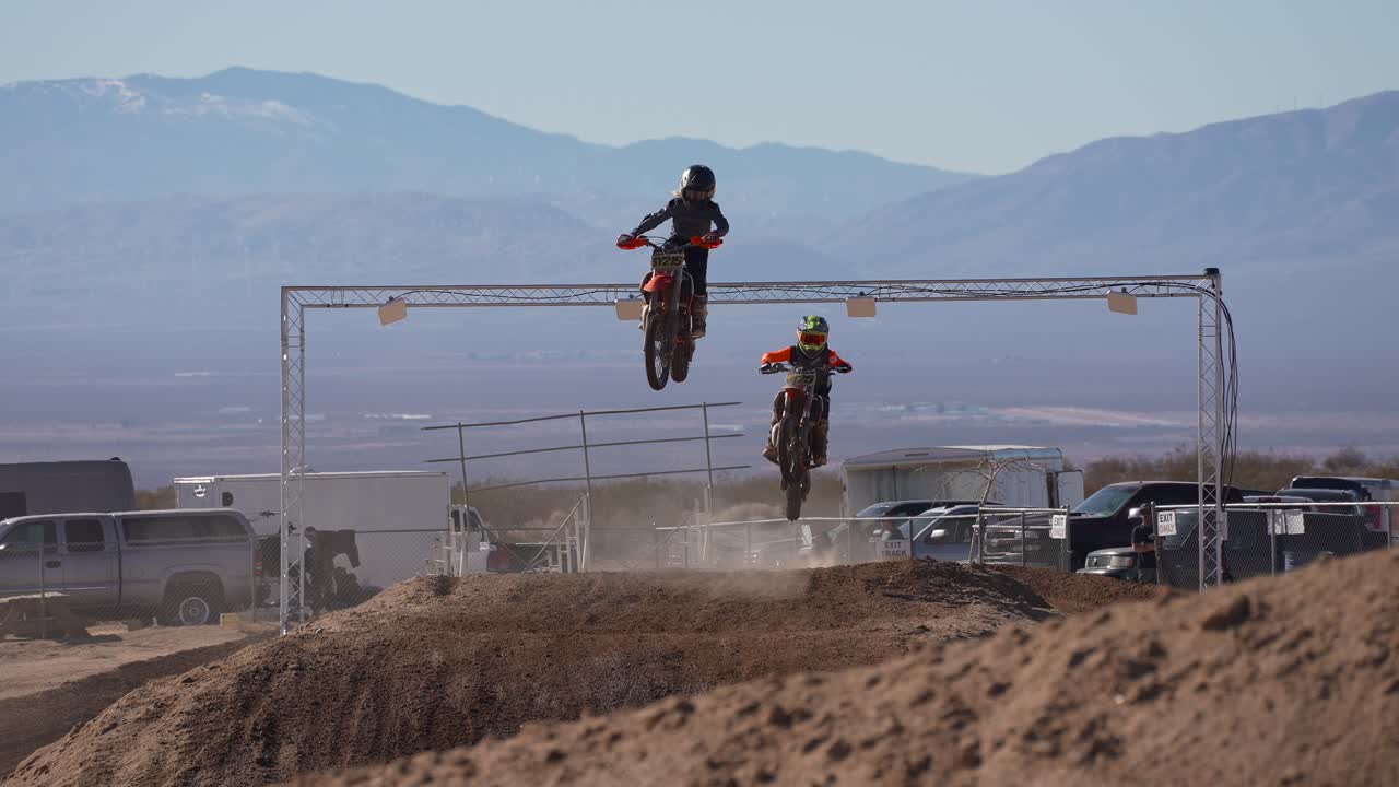 motosikletler, off-road bisiklet yarışları sırasında atlamalar ve yarış pistinde aşağıya doğru uçuyor - yavaş hareket