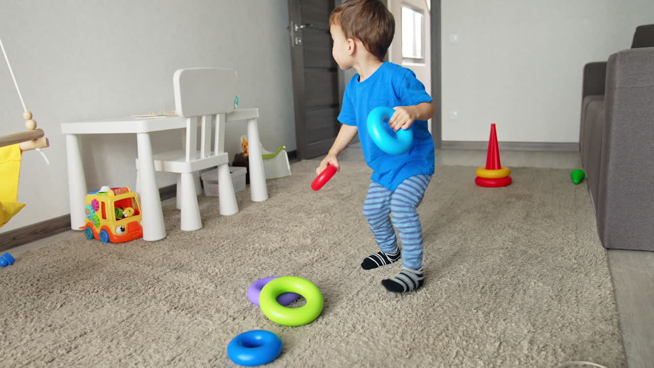Healthy Caucasian child playing with toys at home. Happy active toddler having a game in his room.