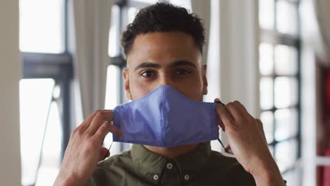 portrait of mixed race man putting mask on