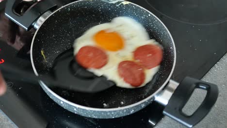 fried eggs with sausage in a pan