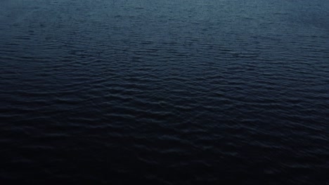 flying over the wavy lake surface in the late afternoon