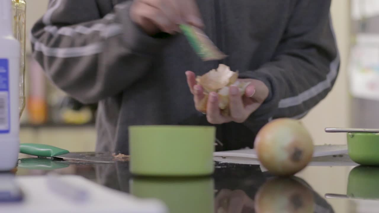 молодая женщина убирает за собой после приготовления пищи