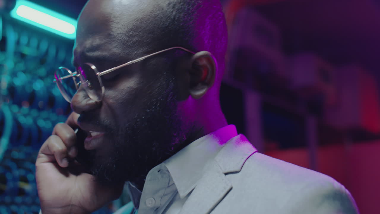 Black IT Professional on a Phone Call in a Data Center