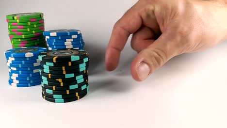 Male-hand-moving-a-black-stack-of-poker-chips-across-the-white-table,-ISOLATED,-STILL