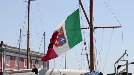 italian flag waving near a docked ship