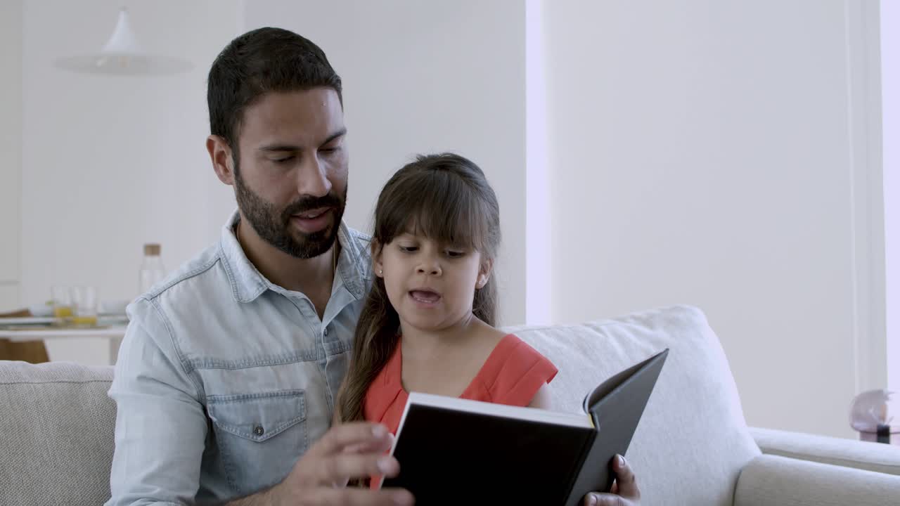 una niña y su padre leyendo un libro juntos