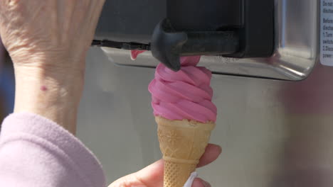 Toma-En-Cámara-Superlenta-De-Una-Vendedora-De-Helados-Preparando-Helado-Suave-Rosa-En-Verano