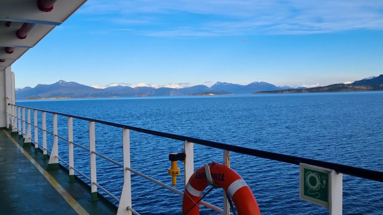 Morgenfährüberfahrt in Chilenisch-Patagonien nahe Puerto Natales, gleitend durch stille Fjorde, umrahmt von fernen Bergketten, mit einem Rettungsring im Vordergrund, der die maritime Sicherheit betont.