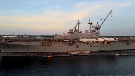 aerial view of aircraft carrier docked at general dynamics nassco shipyard in norfolk, virginia. dolly forward rising shot