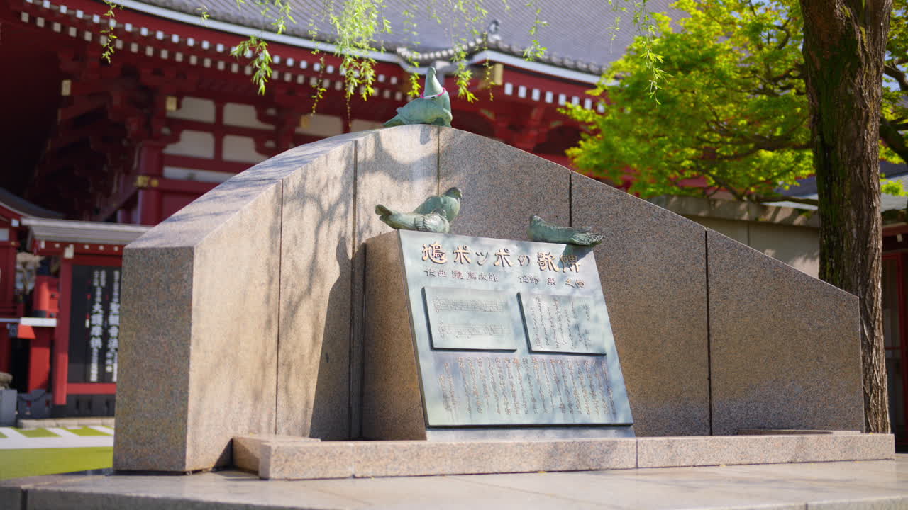 Stone sculpture at the Senso-ji temple in daylight in Tokyo, Japan. Translation: "The title and lyrics of the The Pigeon Song"