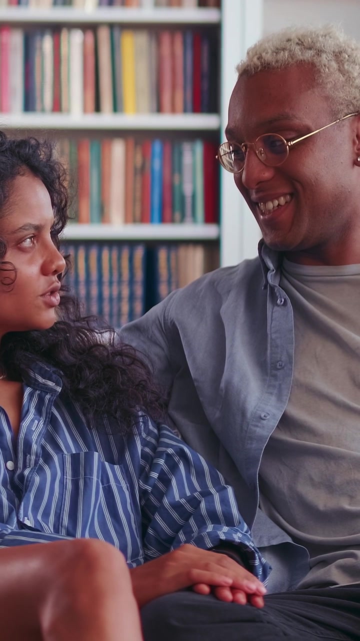Affectionate multiracial couple holding hands and talking