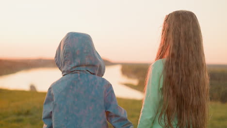 little boy and girl stand together at rainy riverside tranquil brother and contemplate inspiring