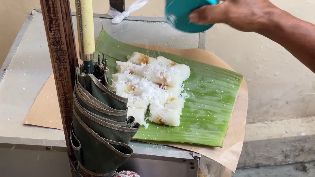 Putu Bambu is a warm, sweet, steamed, cylindrical rice cake with a sweet palm sugar filling, traditionally steamed in a bamboo tube and served with grated coconut and a little sugar