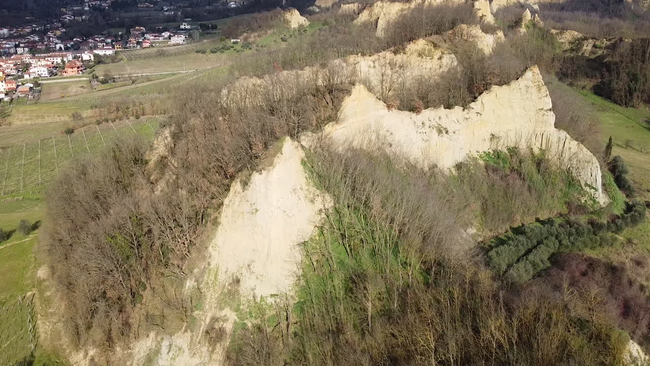 Elevating Aerial flying drone shot over prehistoric age canyons Le Balze natural reserve near Reggello. Tuscany, Chianti area. Italy. Winter season, partially sunny sunset.