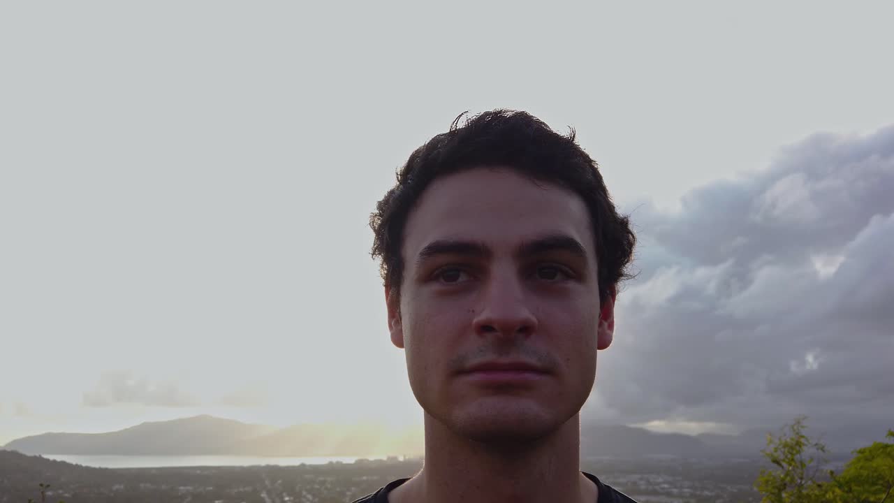 un hombre mirando fijamente al desierto con la espalda hacia la brillante luz del sol - pan de cerca - movimiento lento de izquierda a derecha