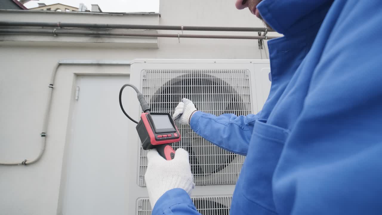 The technician uses a digital camera to check the clogging of the heat exchanger