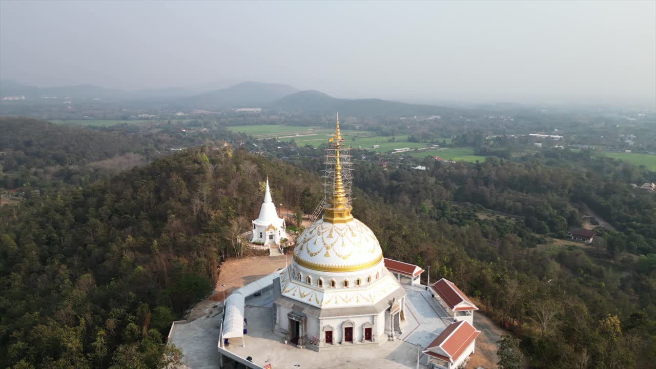 Vista aerea di un tempio buddista con cupola dorata su una collina velata