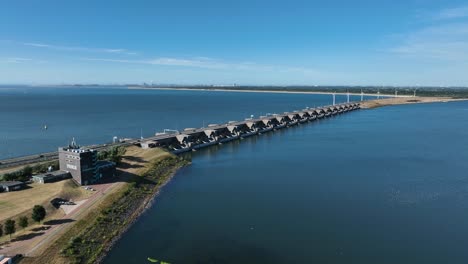 presa de control del nivel del agua de marea deltawerken con turbinas eólicas giratorias