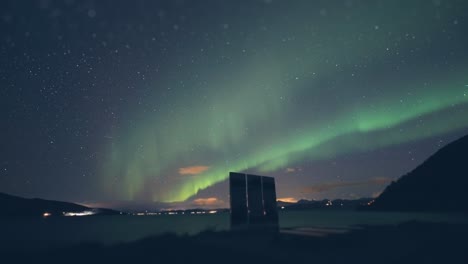 aurora borealis above the battle for narvik memorial on the shore of the fjord