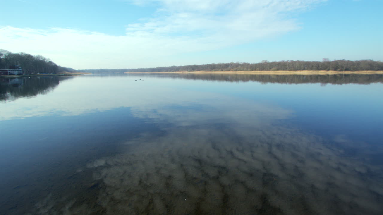 Panning left to right extra Wide shot of Rollesby Broad with sky reflecting in the water taken from the A149 at Ormesby St Margaret