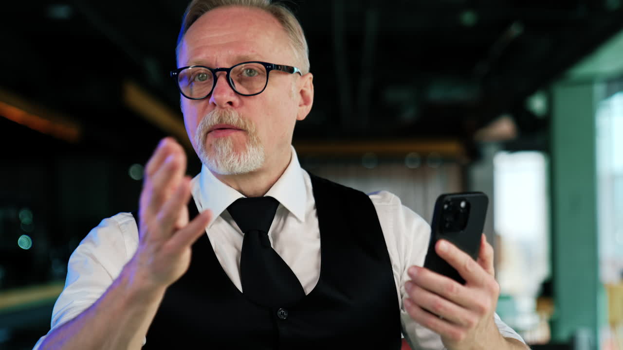 Caucasian adult man in glasses speaks on the video chat. Business conversation via internet. Close up.