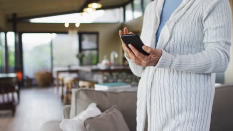 mid section of senior mixed race woman using smartphone