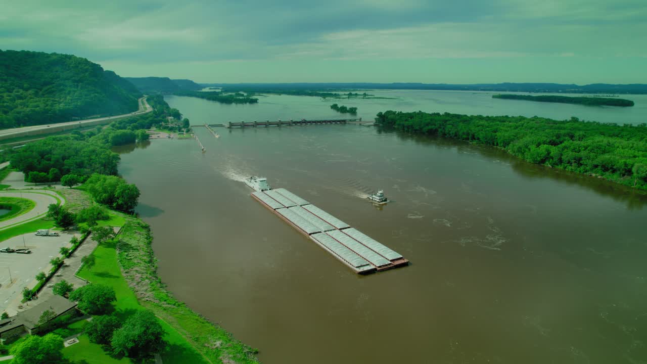 The tug boat pushed the barge, the floating platform in the Missisipi River in Wisconsin, USA