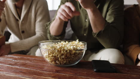 mensen die thuis popcorn eten.