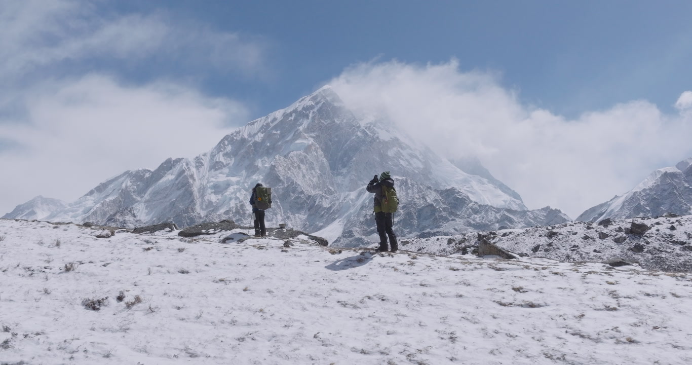 Drone shot of tourists hiking enroute to Everest Base Camp trek taking photos in Khumbu, Nepal. Morning light and reveal snow-capped Himalayan peaks, breathtaking scenery, heavenly travel experiences