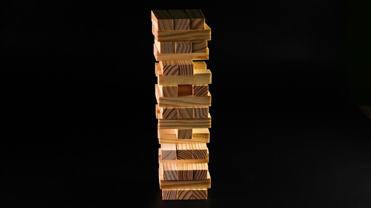 Hand removes block, tower collapses