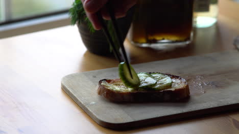 Sliced of picked cucumber on toasted bread