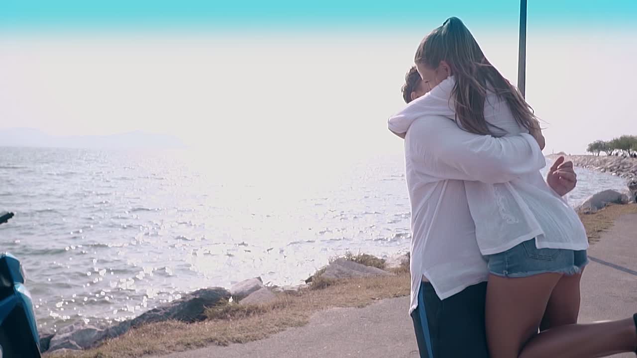 행복한 미소 짓는 남자가 여자친구를 안아주고 키스합니다