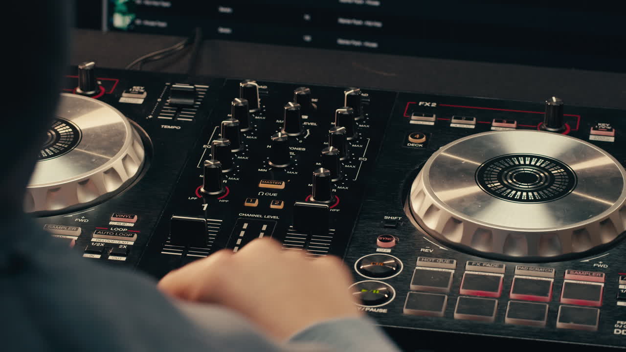 Close-up of a DJ mixing tracks using professional audio equipment for dynamic music production in a club.