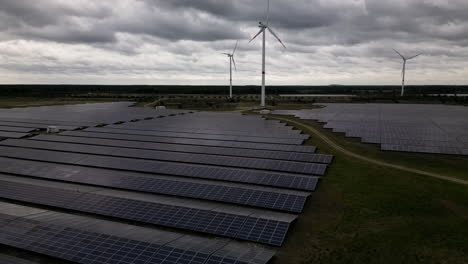 Solar-and-wind-energy-generated-in-fields-of-Belgium,-aerial-view