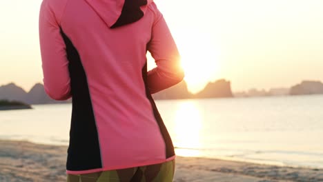 handheld video shows of exercising woman on the beach