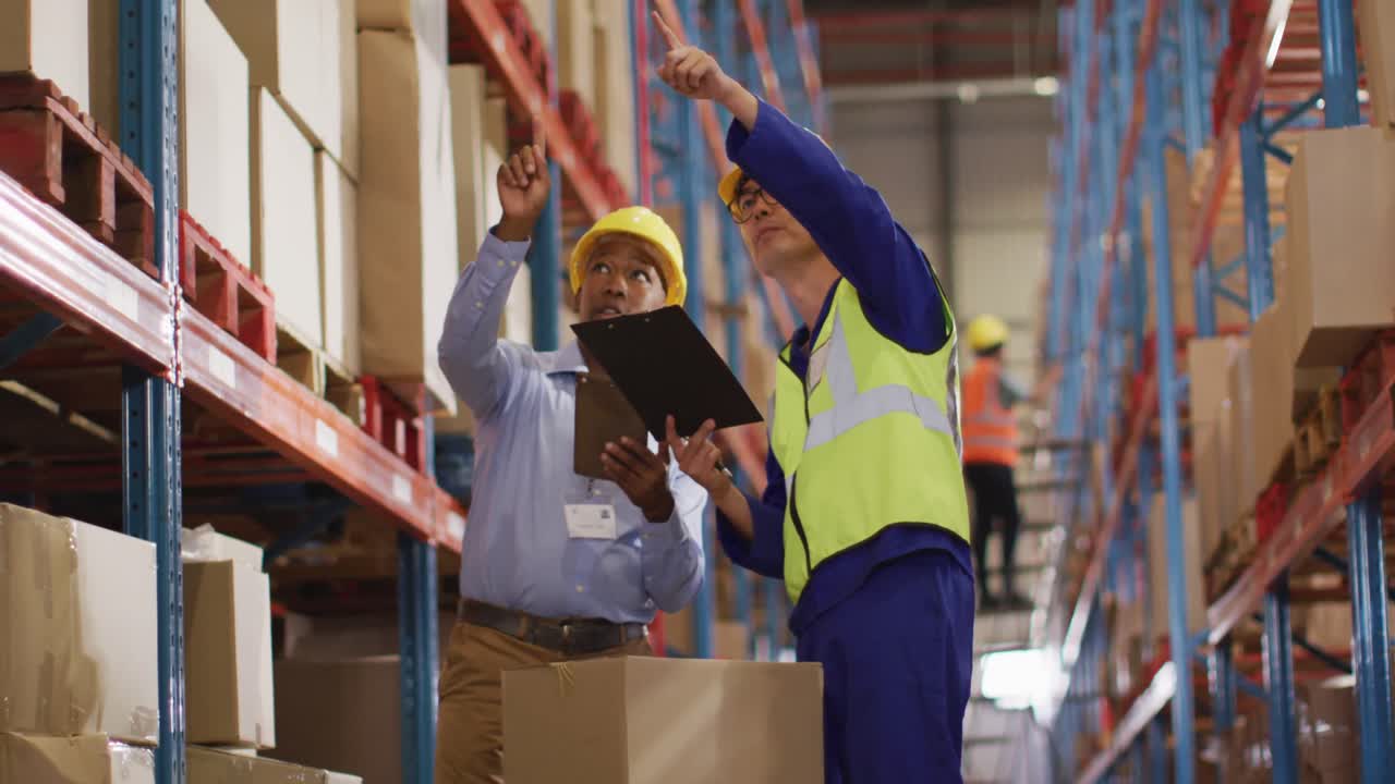 diversos trabajadores varones con trajes de seguridad y hablando en el almacén