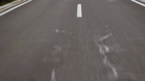 Flying-over-tarmac-road-with-white-lines