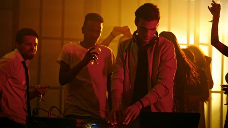 group of clubbers dancing around dj