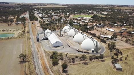 vista aérea descendente de los silos de grano como un remolque lleno de grano recién cosechado se acerca para la descarga