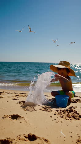 joyful child playing and splashing water on a sunny beach