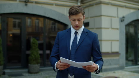 hombre de negocios enfocado leyendo el informe financiero al aire libre