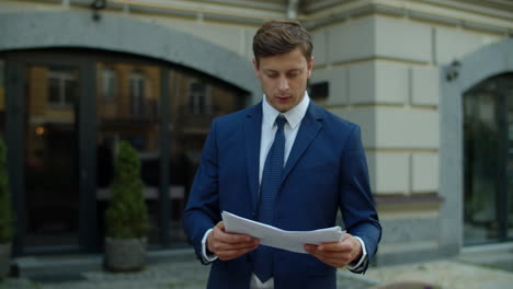 focused businessman reading financial report outdoors