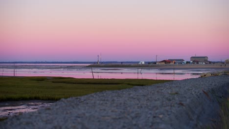 Beautiful-purple-sunset-sky-over-small-waterfront-fishing-oyster-docks-town-France