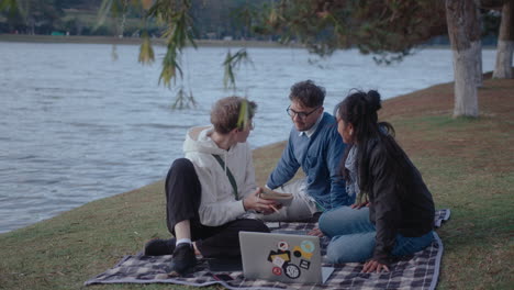 students doing homework with laptop in the park