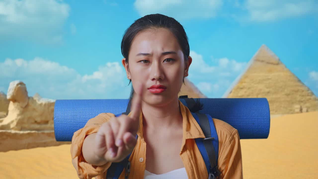 Close Up Of Asian Female Hiker With Mountaineering Backpack Showing No Gesture With Index Finger While Traveling In Pyramid Of Giza