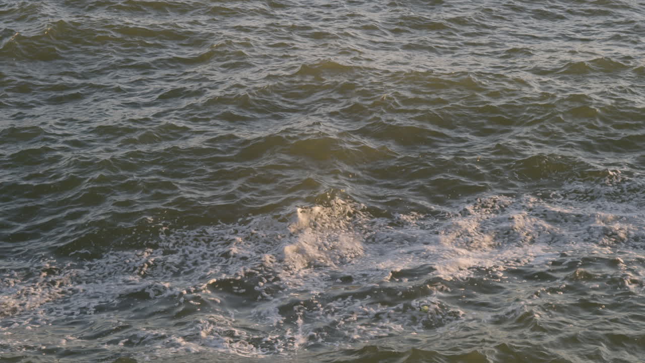 Close view of ocean surface with shimmering light at sunset