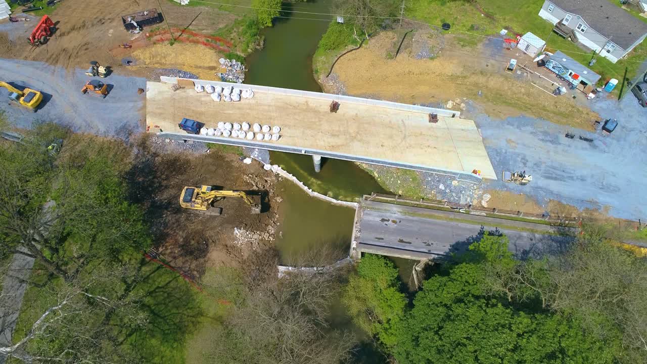 vista aérea de tierras de cultivo y un puente que se está reemplazando sobre un arroyo en un hermoso día soleado