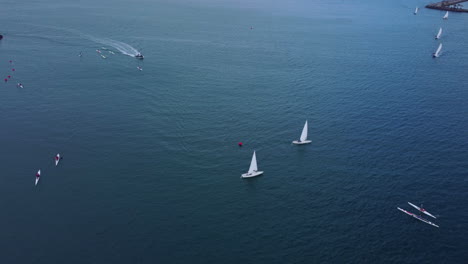 sailing boats and surf ski competitors in the crystal clear water of canary waters in spain