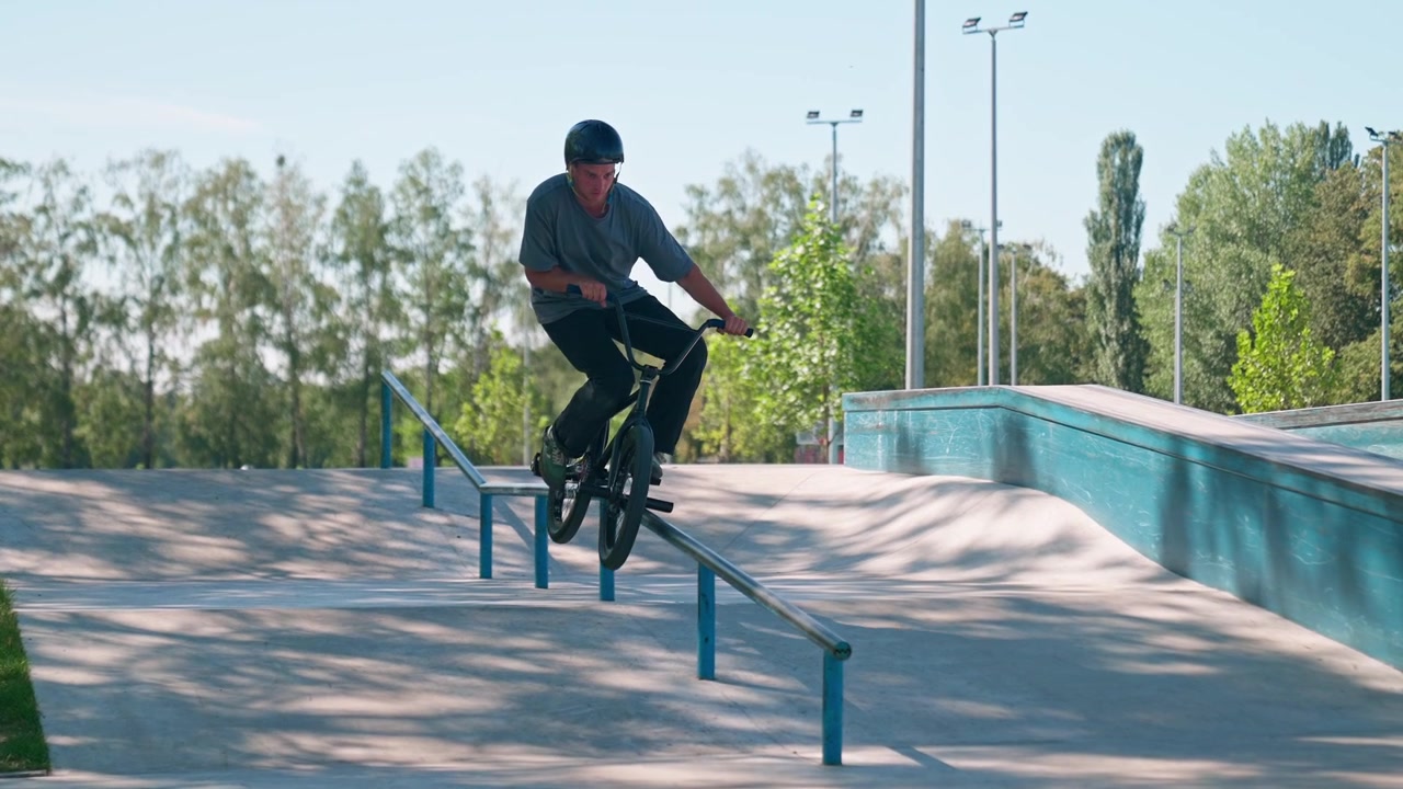 Ragazzo che esegue un trick grind in BMX su un rail allo skatepark