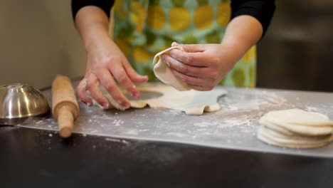 cutting out empanadas from dough